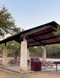 Covered pavilion with picnic tables at a park in San Antonio near La Calera Apartments.